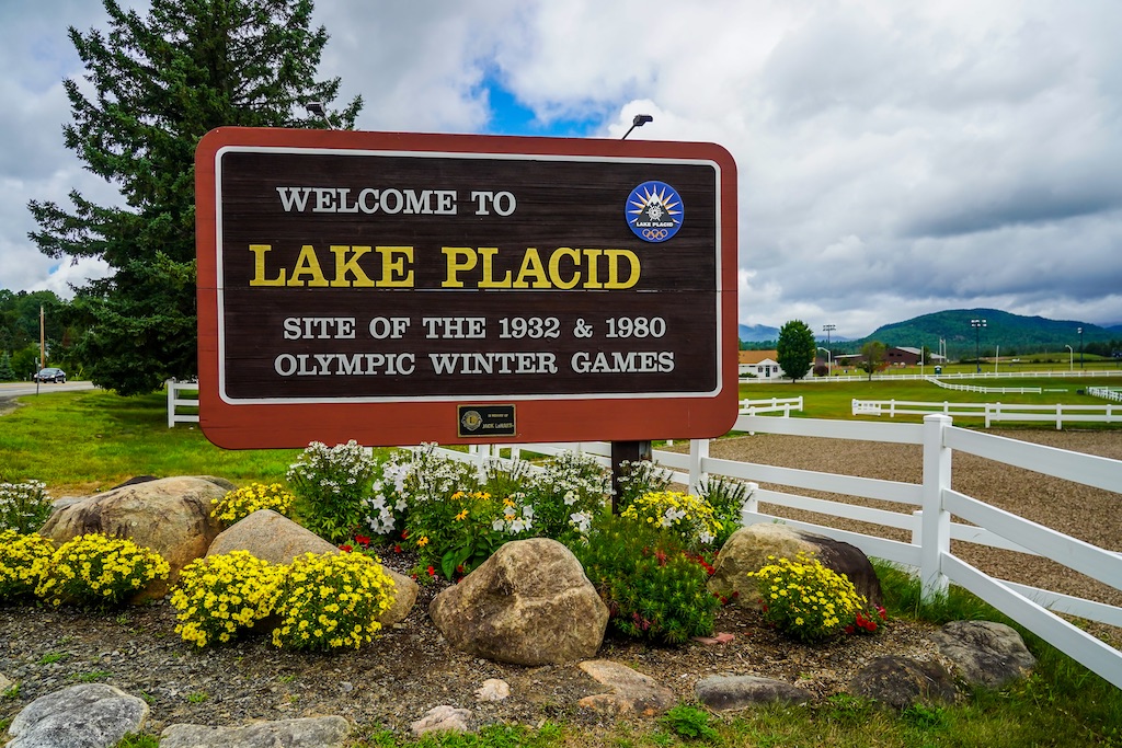 Lake Placid welcome sign surrounded by Adirondack scenery